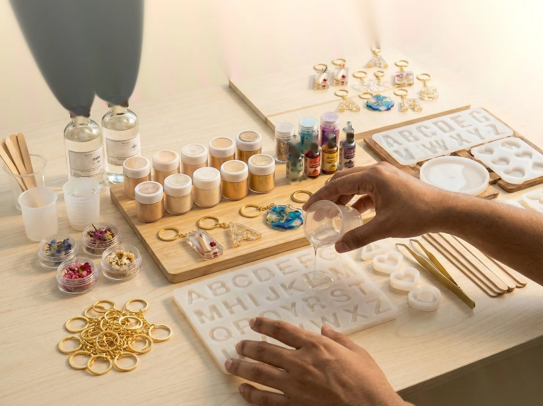 You crafting — hands pouring resin into a mould. 400x280px