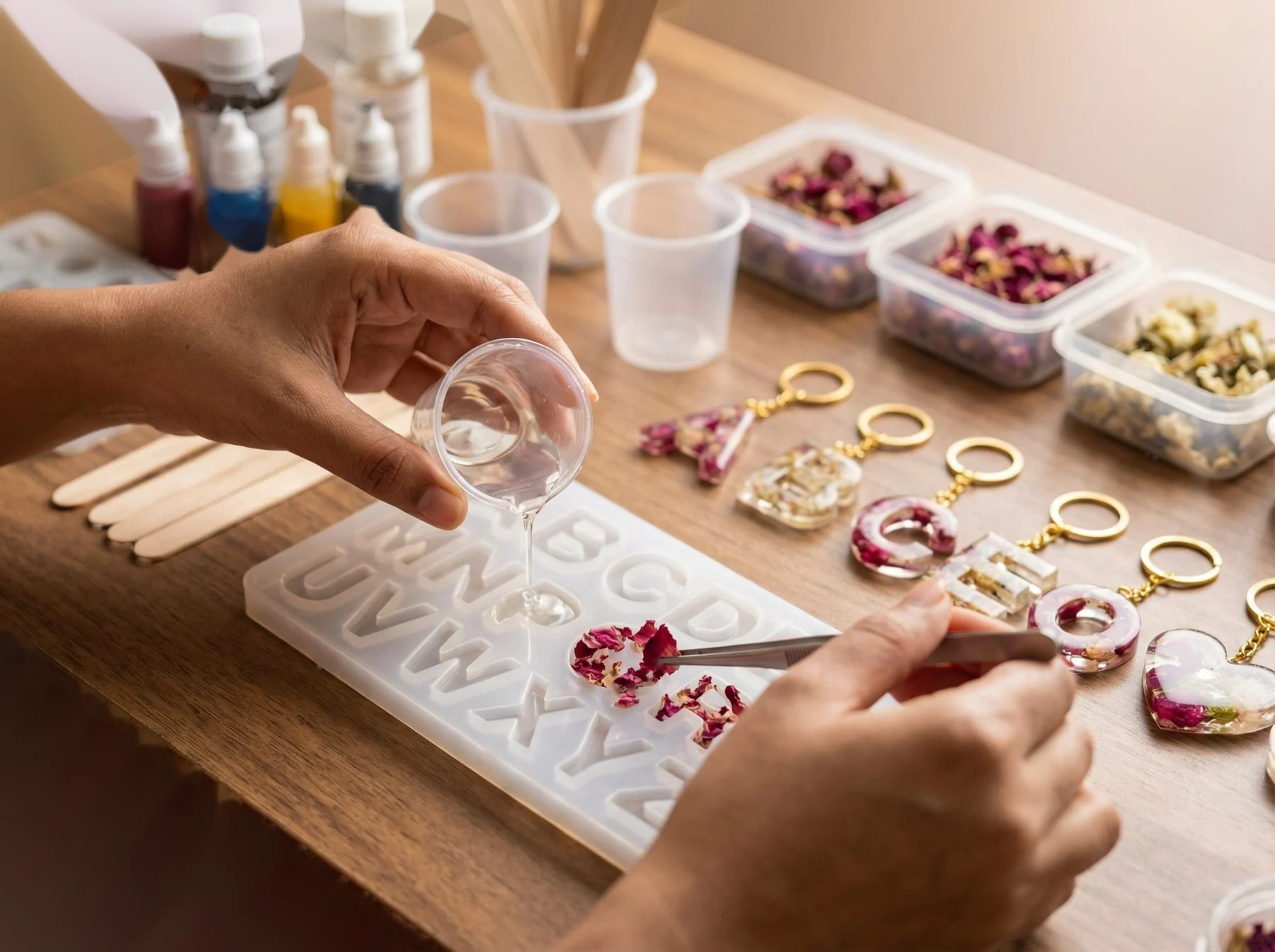 Close-up of hands pouring resin into a mould. Show the craft in action. 400x280px